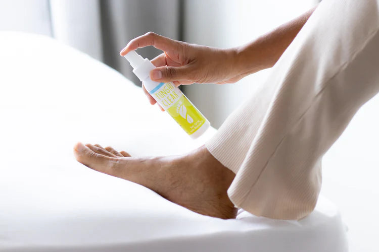A person preparing for a workout by securely tying their white athletic shoe laces while sitting outside. 
Image: 
